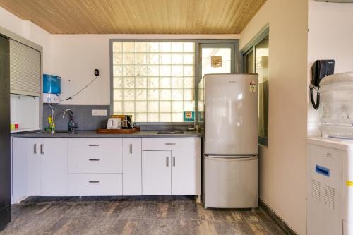a kitchen with white cabinets and a refrigerator at Avanti Tenantry in New Delhi