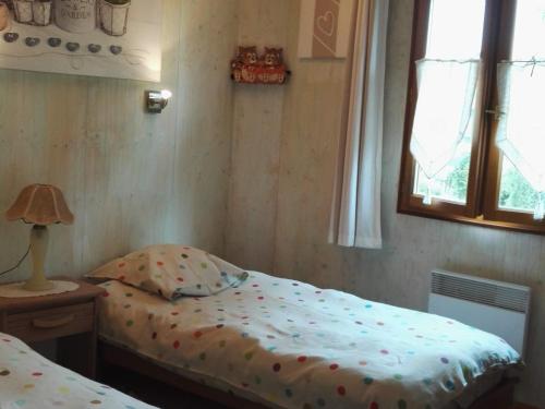une chambre avec un lit, une lampe et une fenêtre dans l'établissement Maison en bois avec jardin, idéal randonnée, fibre haut débit, équipements bébé près du Mans et Tours - FR-1-410-195, à Thoiré-sur-Dinan