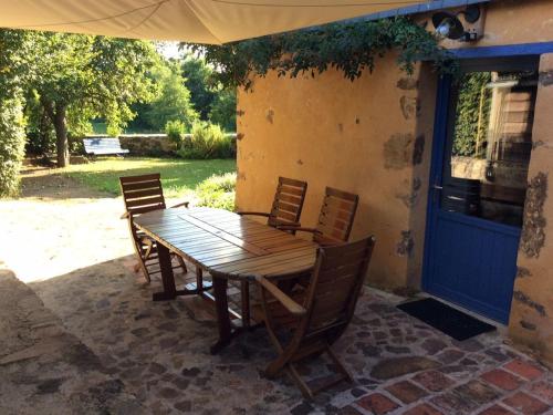 a wooden table and chairs on a patio at Gîte familial restauré en pleine nature avec terrasse, proche forêt, idéal pour groupes et PMR - FR-1-410-255 in Chemiré-en-Charnie