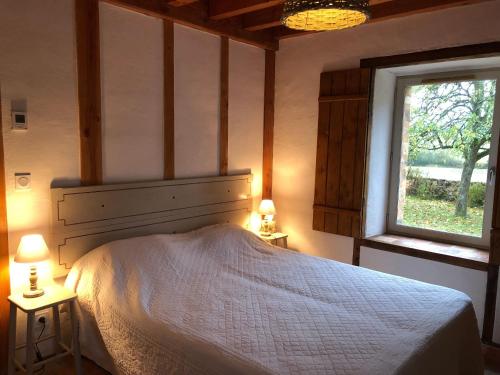 ein Schlafzimmer mit einem Bett und zwei Tischen mit Lampen in der Unterkunft Gîte Chemiré-en-Charnie, 4 pièces, 8 personnes - FR-1-410-255 in Chemiré-en-Charnie