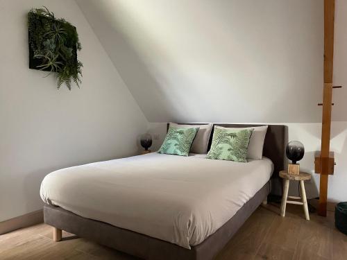 una camera da letto con un letto bianco con cuscini verdi di Gîte de charme proche du Mans pour 6 pers., commerces à pied, tout équipé - FR-1-410-258 a Cérans-Foulletourte