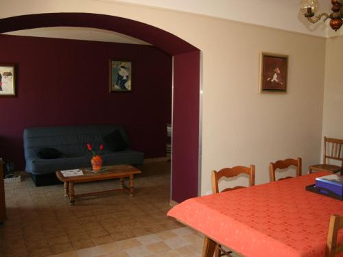 un salon avec un canapé bleu et une table dans l'établissement Maison confortable avec jardin, proche centre-ville et circuit 24h du Mans - FR-1-410-271, au Mans