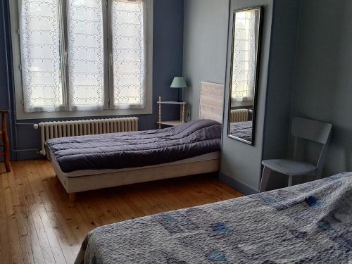 - une chambre avec deux lits, une chaise et deux fenêtres dans l'établissement Maison confortable avec jardin, proche centre-ville et circuit 24h du Mans - FR-1-410-271, au Mans