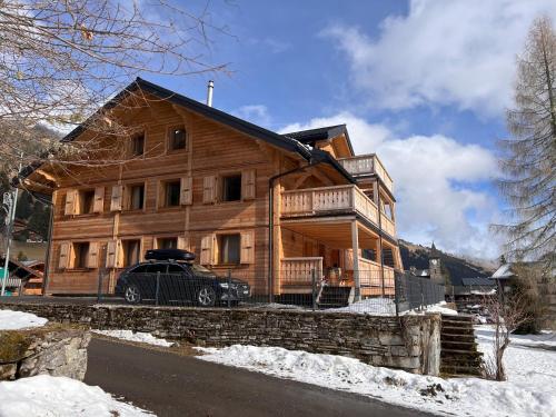 a wooden house with a car parked in front of it at ZE Mountain Lodge, Morgins in Morgins