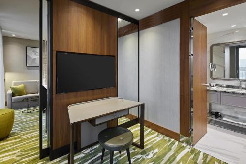 a hotel room with a desk and a tv at TITANIC Chaussee Berlin in Berlin