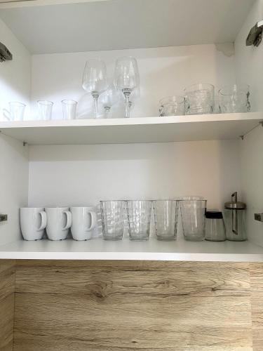 a shelf with glasses and wine glasses on it at Navarino Luxe Suites in Perea