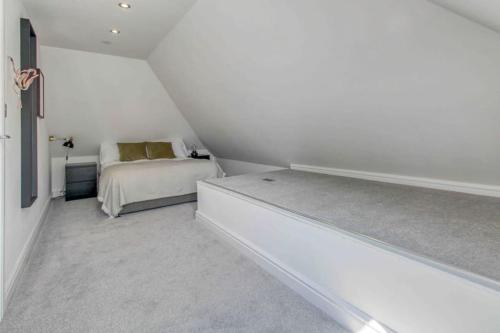 een witte slaapkamer met een bed in een kamer bij Stunning Two Bed House in City Centre, Southampton in Southampton