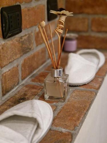 a bathroom counter with two white plates and a vase with sticks at Mia Monza Suite in Monza