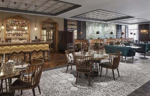 a restaurant with tables and chairs and a bar at TITANIC Chaussee Berlin in Berlin