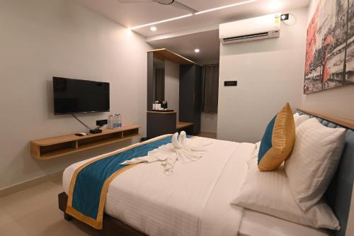 a bedroom with a large bed with a tv on the wall at KP Hotels in Begusarai