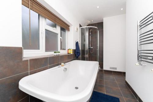 a bathroom with a large white tub and a shower at Luxury home in Gerrards Cross in Chalfont Saint Peter