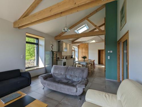 un salon avec un canapé et une table dans l'établissement Gîte au calme avec équipements PMR, parking, animal accepté - FR-1-582-59, à Saint-Préjet-dʼAllier