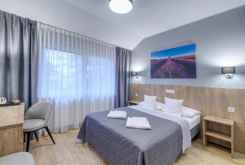 Una habitación de hotel con una cama con dos toallas. en Lawendowy Dwór, en Pszczółki