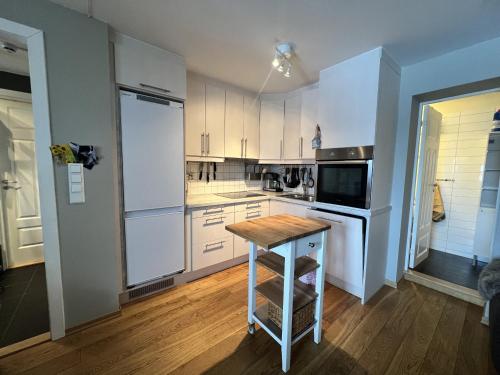 uma cozinha com armários brancos e uma mesa de madeira em Cosy Apartement close to Geilo em Geilo