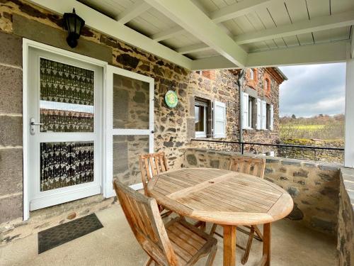 un patio avec une table, des chaises et une fenêtre dans l'établissement Charmant Gîte à Lavaudieu avec Terrasse, Proche Sites Touristiques et Commerces - FR-1-582-219, à Lavaudieu
