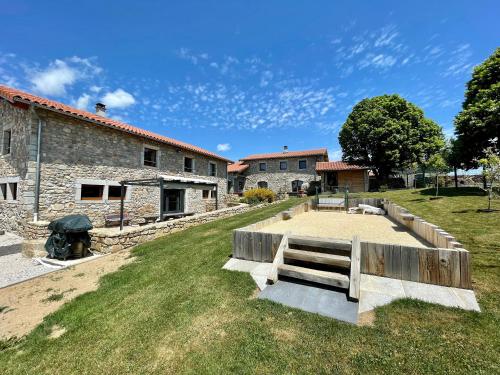 a patio in front of a stone building at Grand gîte cosy avec terrasse, jardin et jeux à Boisset, proche villages médiévaux et loisirs nature - FR-1-582-246 in Boisset