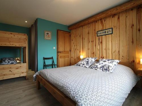 ein Schlafzimmer mit einem Bett und einer Holzwand in der Unterkunft Gîte Boisset, 5 pièces, 12 personnes - FR-1-582-246 in Boisset