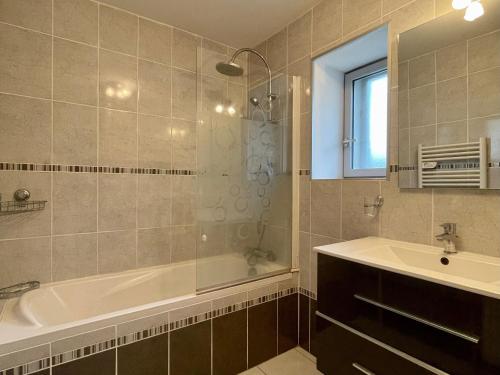 a bathroom with a bath tub and a sink at Ferme du XIXe siècle avec cour fermée et terrasse, proche des gorges de la Loire et du Puy-en-Velay - FR-1-582-187 in Saint-Vincent