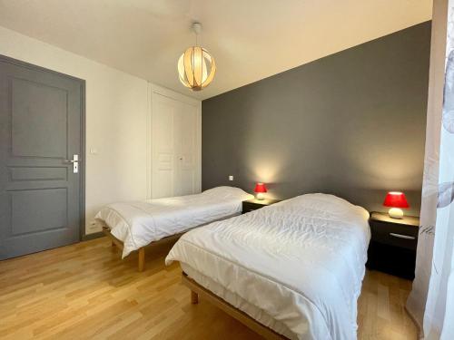 1 dormitorio con 2 camas y 2 lámparas en las mesas en Gîte Saint-Vincent, 4 pièces, 6 personnes - FR-1-582-187 en Saint-Vincent