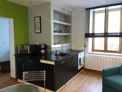 une cuisine avec un comptoir noir dans une pièce dans l'établissement Appartement 40m² lumineux avec cuisine équipée, Wi-Fi gratuit, proche mairie et église à Fay - FR-1-410-301, à Fay