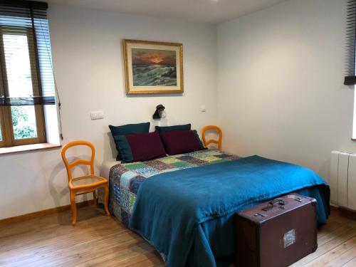 ein Schlafzimmer mit einem Bett mit einer blauen Decke und einem Stuhl in der Unterkunft Appartement 40m² lumineux avec cuisine équipée, Wi-Fi gratuit, proche mairie et église à Fay - FR-1-410-301 in Fay