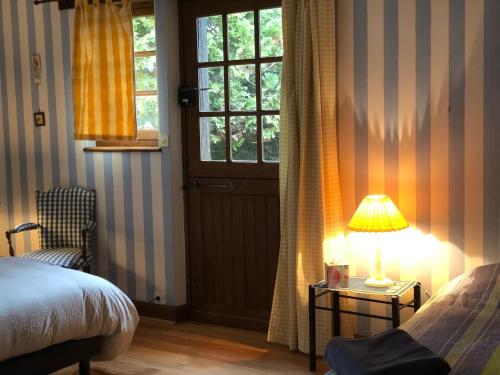 a bedroom with a bed and a table with a lamp at Évasion champêtre : Maison avec piscine, tennis, et étang au cœur de 50 hectares de forêt - FR-1-410-307 in Le Lude