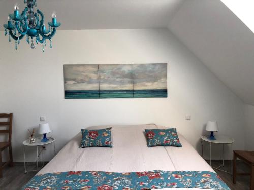 a bedroom with a bed and two tables and a chandelier at Moulin Authentique avec Pêche, Animaux Acceptés et Confort Moderne près du Mans - FR-1-410-323 in Mézières-sur-Ponthouin