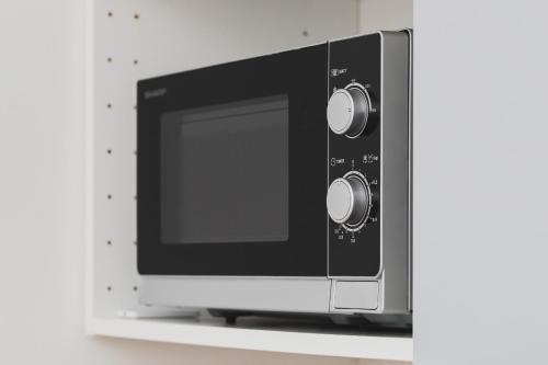 a microwave oven sitting on top of a shelf at Studio Apartment near River and Park by Rent like home in Gdańsk