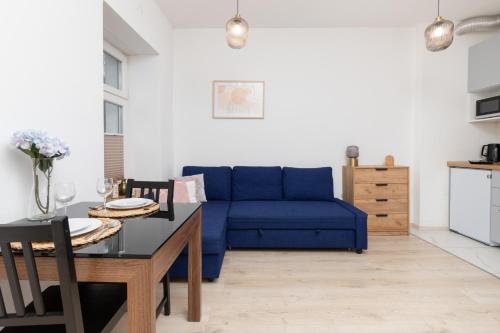 a living room with a blue couch and a table at Studio Apartment near River and Park by Rent like home in Gdańsk