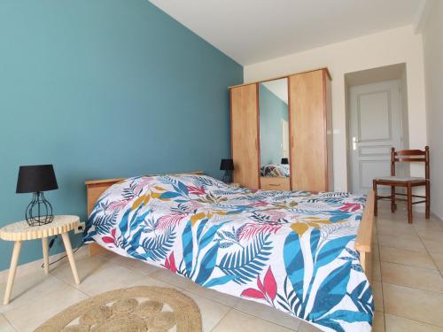 ein Schlafzimmer mit einem Bett mit einer farbenfrohen Tagesdecke in der Unterkunft Gîte de charme 4 pers avec spa privatif, terrasse, et équipements complets au cœur d'un village viticole - FR-1-622-20 in La Viardière