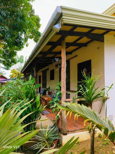 a house with a covered porch with plants at Rene's Diverslounge Resort in Calape