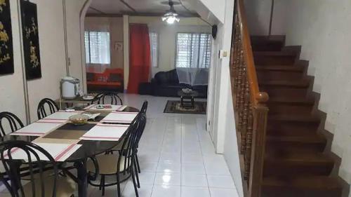 a dining room with a table and chairs and a staircase at Santarem uri del flu in Iloilo City