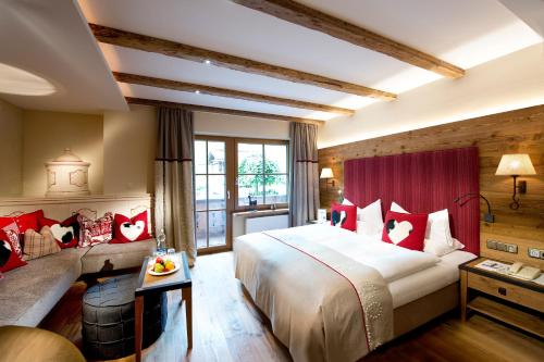 a hotel room with a bed and a couch at Hotel Alpin Spa Tuxerhof in Tux