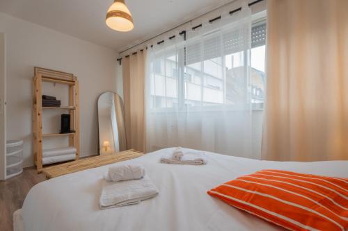ein Schlafzimmer mit einem weißen Bett und Handtüchern darauf in der Unterkunft MUL HOUSE in Mulhouse