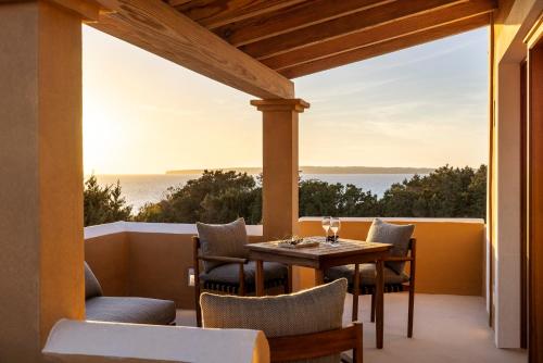un patio con mesa y sillas y vistas al océano en Dunas de Formentera, en Es Arenals