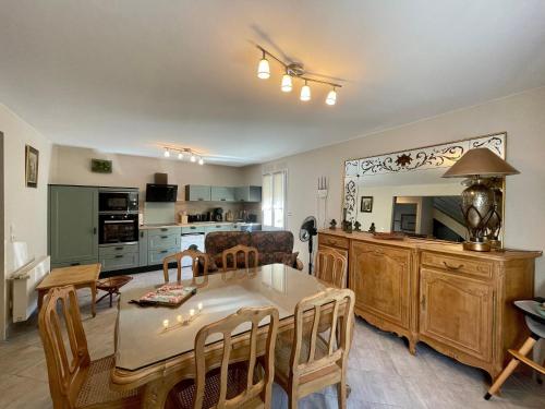 une cuisine et un salon avec une table et des chaises dans l'établissement Gîte cosy à Aiguilhe avec jardin, jacuzzi et sauna - proche UNESCO et chemins de randonnée - FR-1-582-354, à Aiguilhe