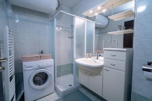 a bathroom with a washing machine and a sink at Apartment Maj, Kranjska Gora in Kranjska Gora