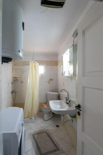 a bathroom with a toilet and a sink at Rustic House in Plaka in Plaka Milou