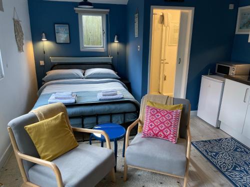 Habitación pequeña con 1 cama y 2 sillas en Fistral Studio, en Newquay