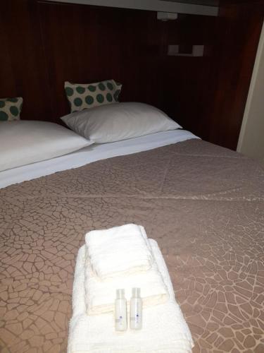 Una cama con toallas blancas y almohadas. en L'antico borgo, en Agrigento