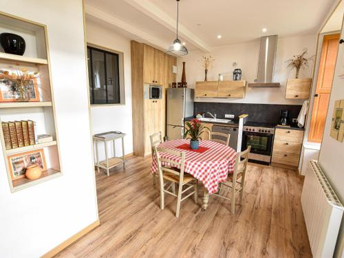 une cuisine et une salle à manger avec une table et des chaises dans l'établissement Gîte restauré 6 pers. au bord de la rivière, proche centre, parking et wifi - FR-1-410-380, à Sablé-sur-Sarthe