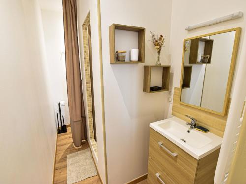 ein Bad mit einem Waschbecken und einem Spiegel in der Unterkunft Gîte Sablé-sur-Sarthe, 3 pièces, 6 personnes - FR-1-410-380 in Sablé-sur-Sarthe