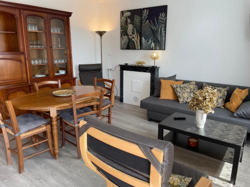 un salon avec une table et un canapé dans l'établissement Séjour au Bord de l’eau - Moulin Authentique avec Pêche et Confort Moderne - FR-1-410-393, à Mézières-sur-Ponthouin