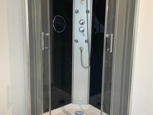 una doccia con una porta in vetro in un bagno di Gîte de charme près du Mans, tout équipé avec espace extérieur, garage, et confort moderne - FR-1-410-385 a La Bosse