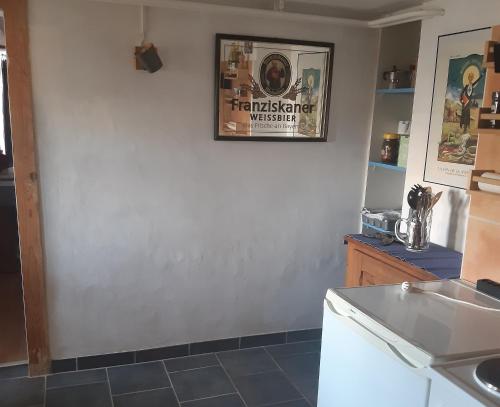 eine Küche mit einer weißen Wand und einem Waschbecken in der Unterkunft Au Grizz in Tramelan