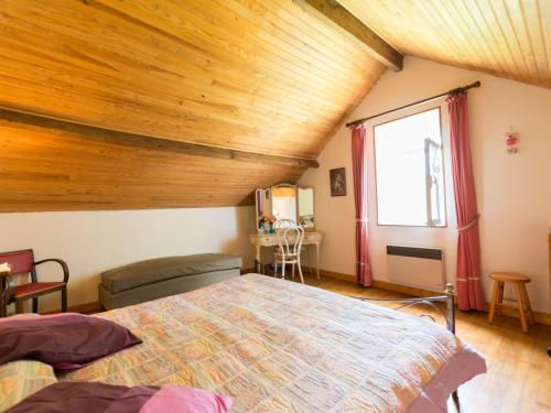 una camera con letto e soffitto in legno di Gîte Thorée-les-Pins, 4 pièces, 7 personnes - FR-1-410-390 a Thorée-les-Pins