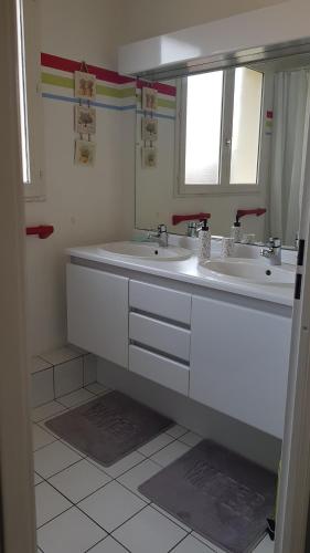 un bagno bianco con due lavandini e uno specchio di Chez Laurence & RV a Vauréal