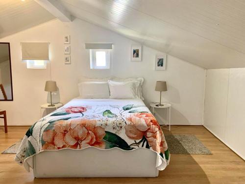 a white bedroom with a bed with a floral bedspread at Central Avenida Liberdade 2 in Lisbon