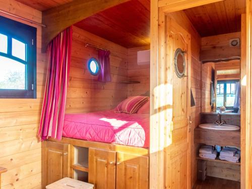 a bedroom with a bed in a log cabin at Roulotte climatisée avec piscine et jardin - FR-1-622-54 in Vihiers