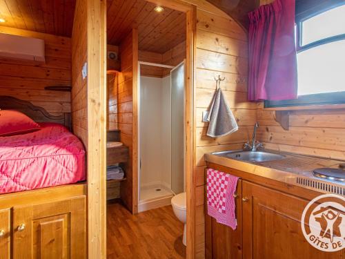 a bathroom with a sink and a bed in a cabin at Roulotte climatisée avec piscine et jardin - FR-1-622-54 in Vihiers